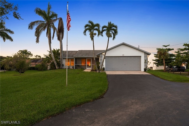 ranch-style home featuring a yard and a garage