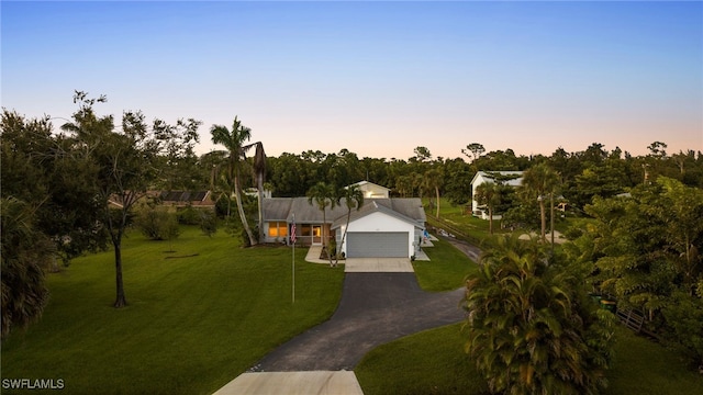 view of front of home with a yard and a garage