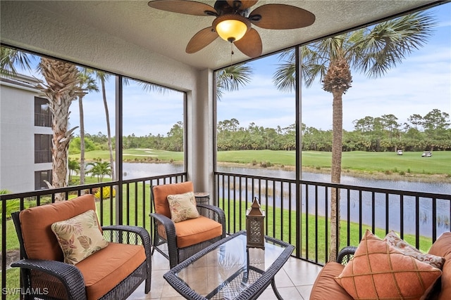 sunroom / solarium with a water view and ceiling fan