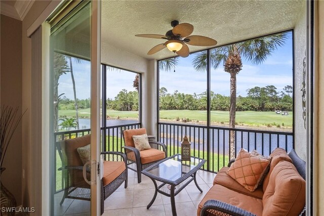 sunroom featuring a water view and ceiling fan