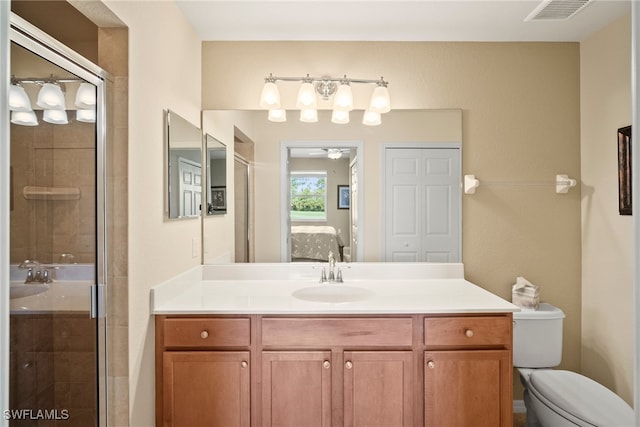 bathroom featuring walk in shower, toilet, and vanity