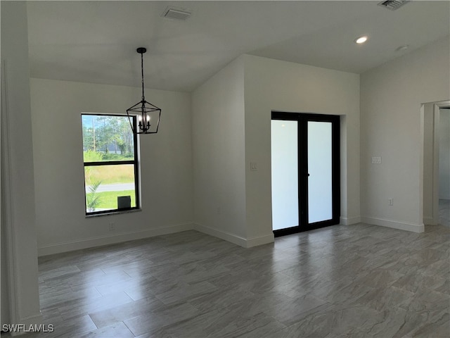 unfurnished room featuring a chandelier