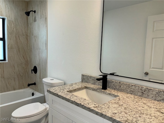 full bathroom with tiled shower / bath, vanity, and toilet