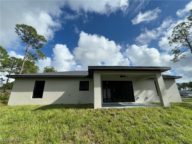 back of property featuring a patio area, a lawn, and ceiling fan