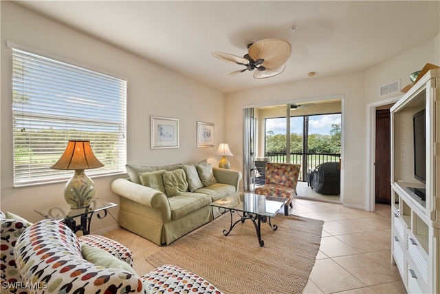 living room featuring plenty of natural light, light tile patterned floors, and ceiling fan