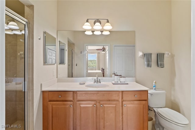 bathroom featuring vanity, toilet, ceiling fan, and walk in shower