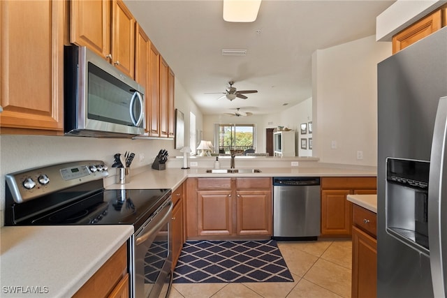 kitchen with appliances with stainless steel finishes, light tile patterned floors, sink, and ceiling fan