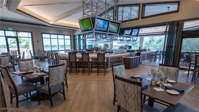 dining area with light wood-type flooring and indoor bar