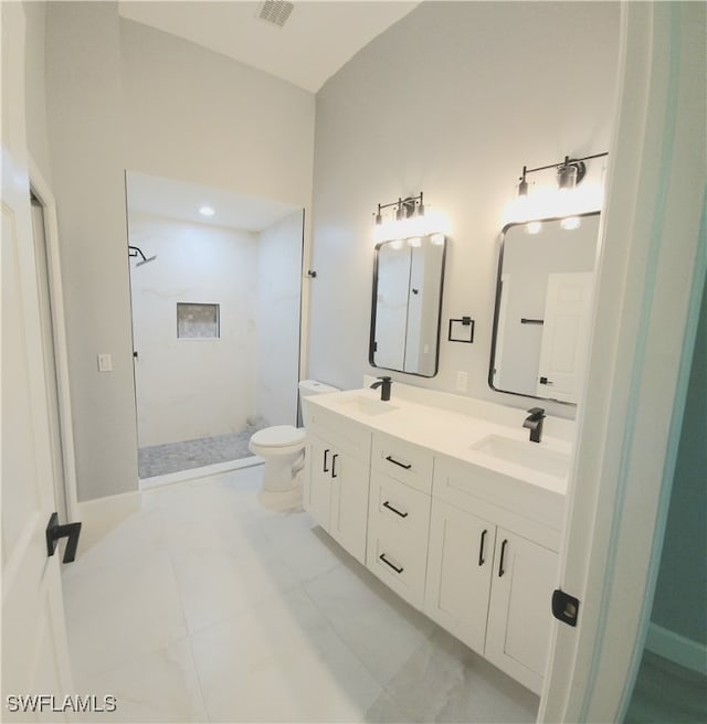 bathroom featuring tile patterned flooring, a shower, vanity, and toilet