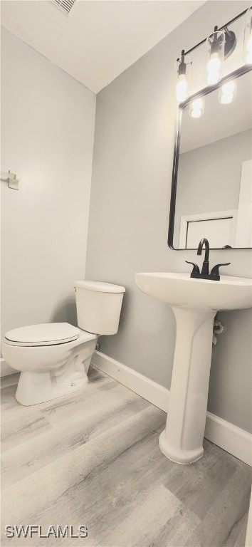 bathroom with wood-type flooring, sink, and toilet