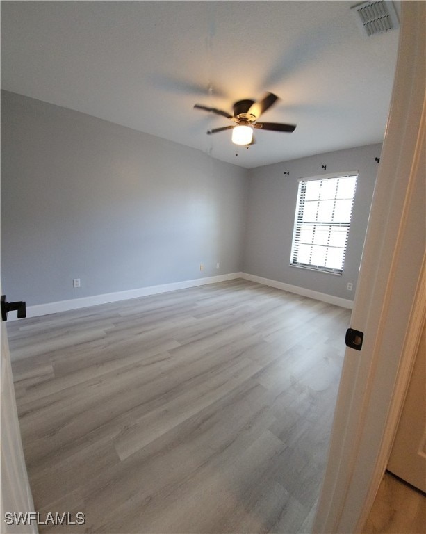 spare room with light hardwood / wood-style floors and ceiling fan