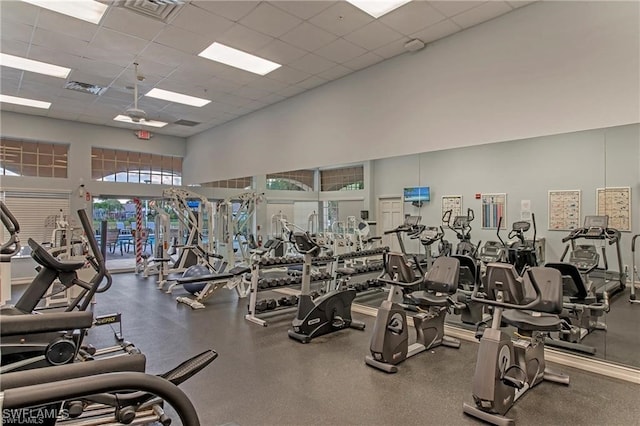 gym featuring a paneled ceiling and a high ceiling