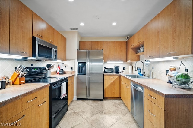 kitchen featuring stainless steel appliances, sink, decorative backsplash, and light tile patterned flooring