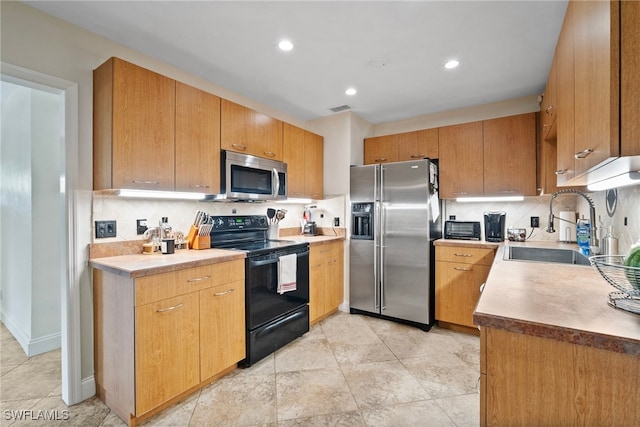 kitchen featuring sink, appliances with stainless steel finishes, and decorative backsplash