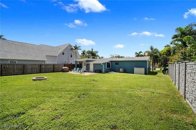 view of yard with cooling unit, an outdoor fire pit, and a patio