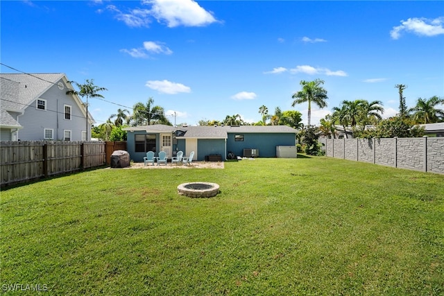 view of yard featuring a fire pit, a patio area, and central AC