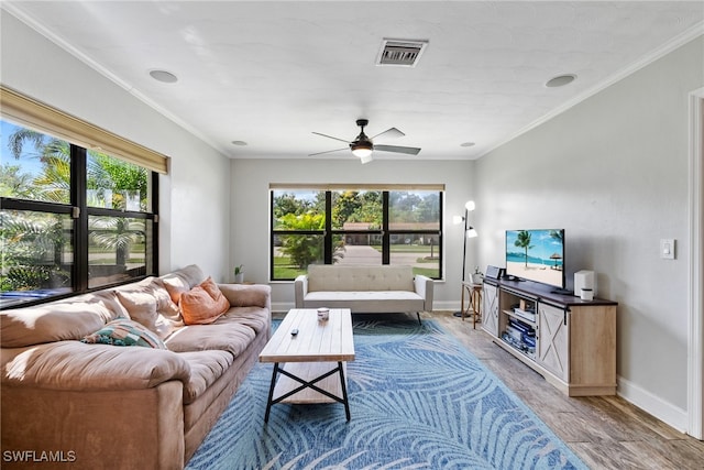 living room featuring ceiling fan, plenty of natural light, crown molding, and wood-type flooring