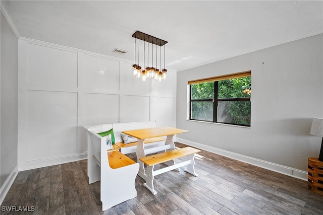 dining area featuring dark wood-type flooring and ornamental molding