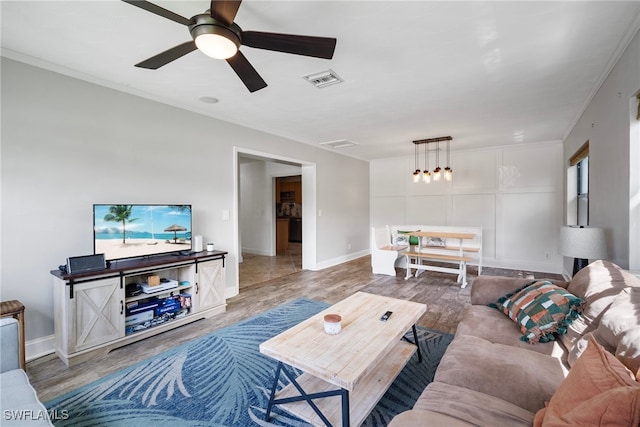 living room featuring crown molding, ceiling fan, and hardwood / wood-style flooring