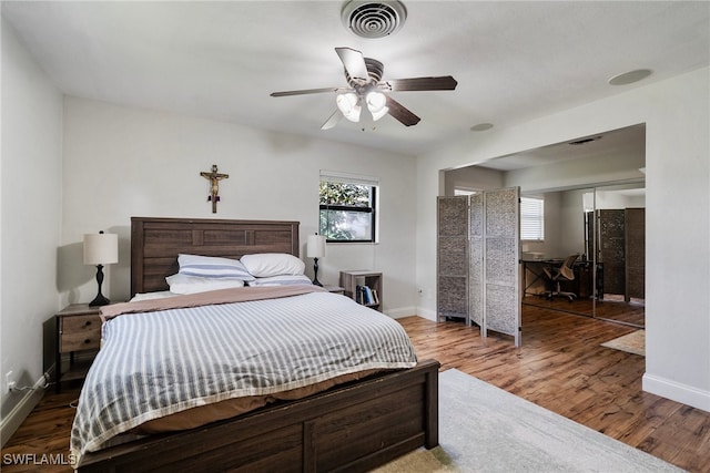 bedroom with hardwood / wood-style floors, ceiling fan, and a closet