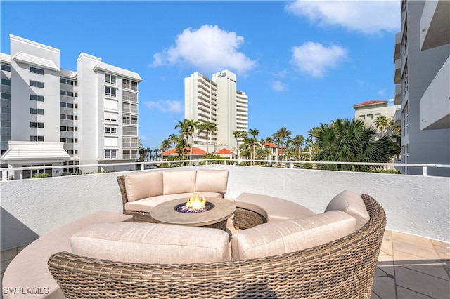 view of patio / terrace with an outdoor fire pit and a balcony