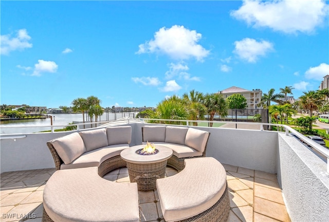 view of patio / terrace featuring a balcony, a water view, and a fire pit