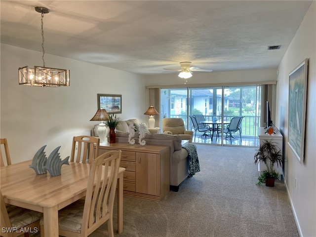 carpeted dining room featuring a textured ceiling and ceiling fan with notable chandelier