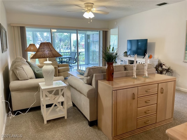 carpeted living room with ceiling fan