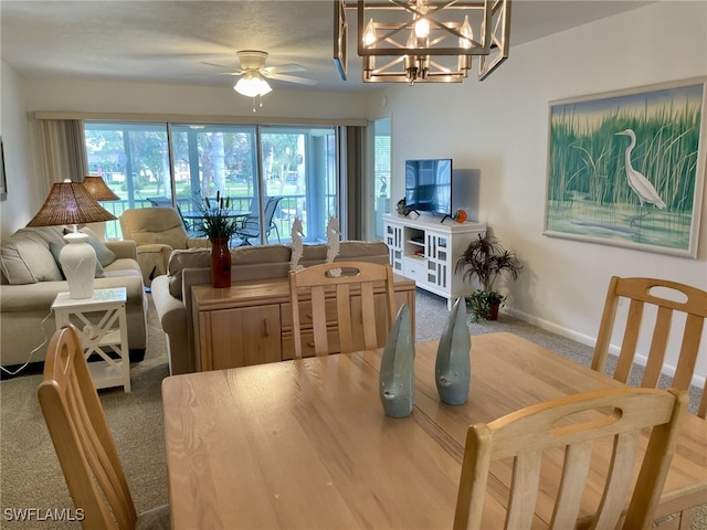 dining area featuring carpet flooring and ceiling fan with notable chandelier