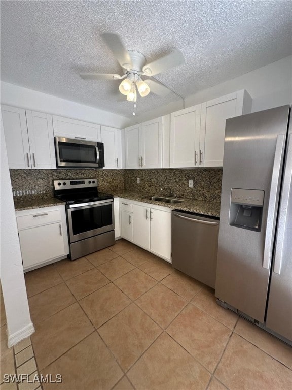 kitchen featuring a textured ceiling, white cabinetry, stainless steel appliances, and ceiling fan