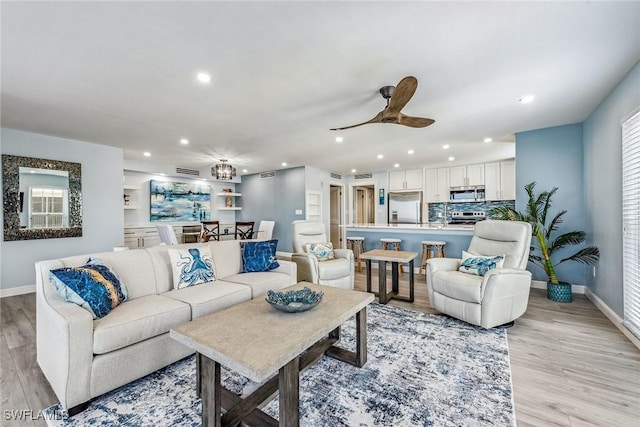 living room with light hardwood / wood-style floors and ceiling fan