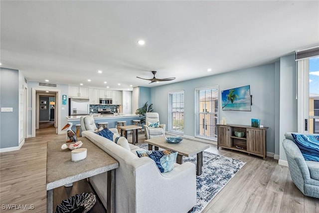 living room with light hardwood / wood-style floors and ceiling fan