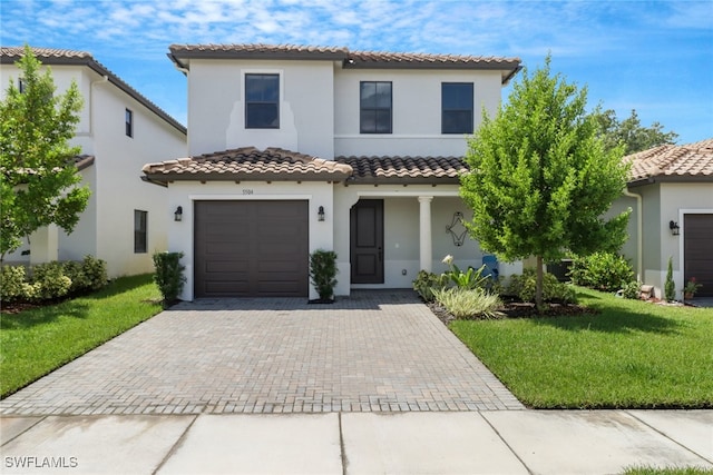 mediterranean / spanish house featuring a garage and a front yard