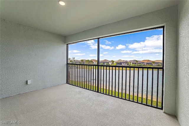 unfurnished sunroom featuring a water view