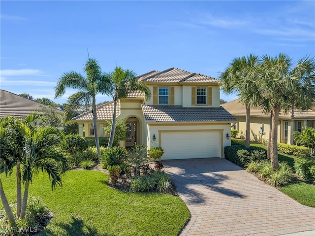 mediterranean / spanish-style house featuring a garage and a front lawn