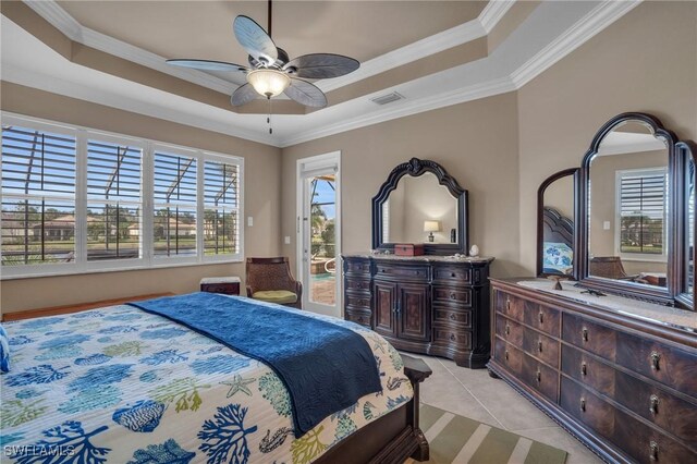 tiled bedroom with ornamental molding, a tray ceiling, and ceiling fan