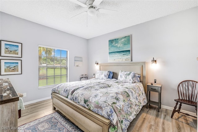 bedroom featuring light wood-type flooring, ceiling fan, and a textured ceiling