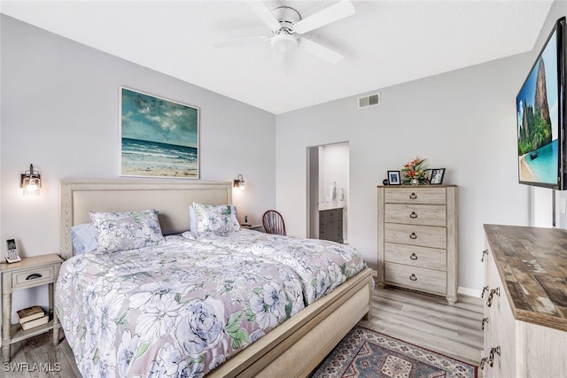 bedroom with ceiling fan, light hardwood / wood-style flooring, and connected bathroom