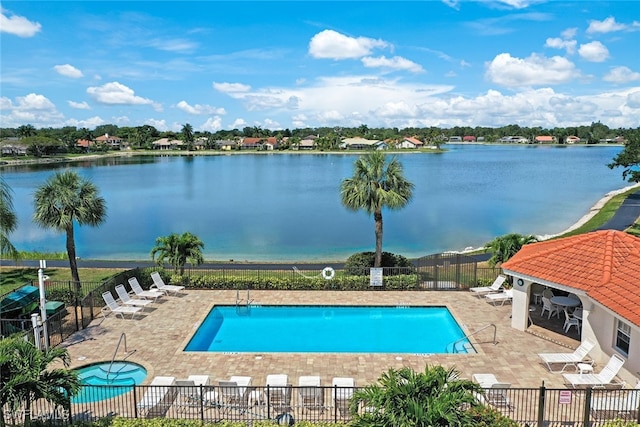 view of swimming pool with a patio and a water view