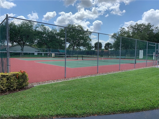 view of tennis court with a yard