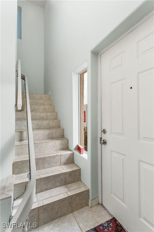 staircase with tile patterned floors and plenty of natural light