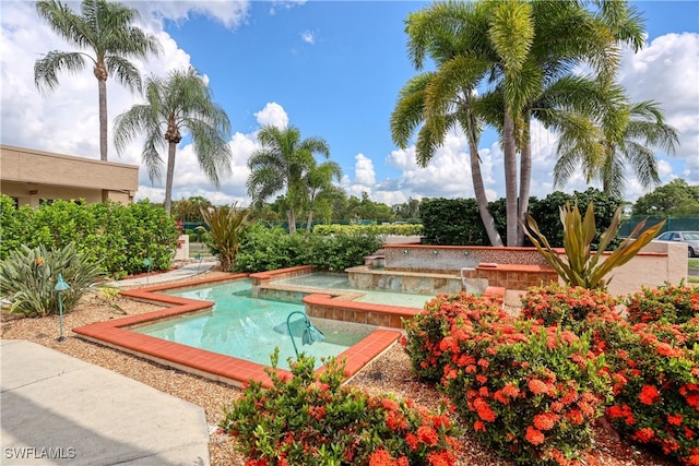 view of property's community featuring a swimming pool with hot tub