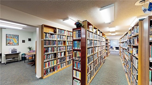 interior space with a textured ceiling and carpet flooring