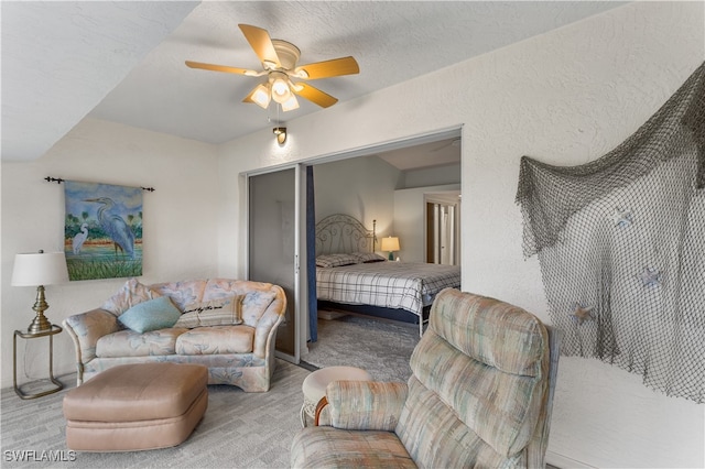 carpeted bedroom featuring a textured ceiling and ceiling fan