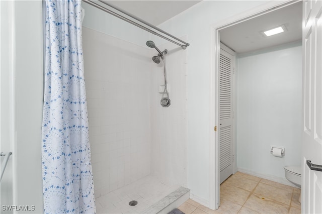 bathroom with tile patterned flooring, toilet, and a shower with shower curtain