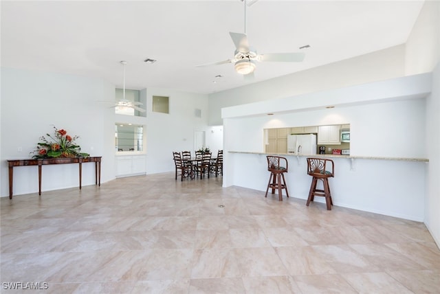 interior space with ceiling fan and a towering ceiling