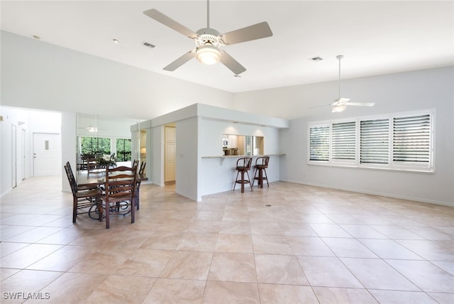 tiled dining space featuring lofted ceiling, plenty of natural light, and ceiling fan