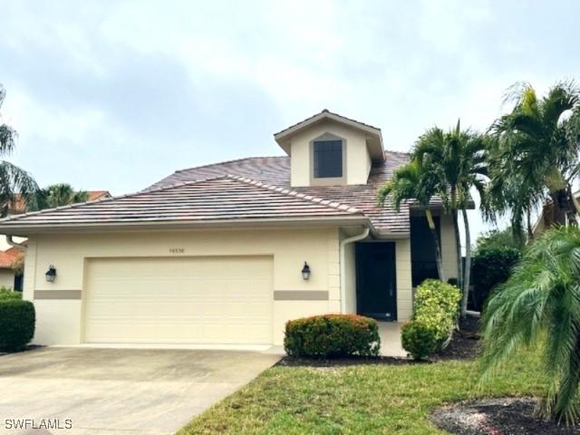 view of front of property featuring a garage, concrete driveway, a tile roof, and stucco siding