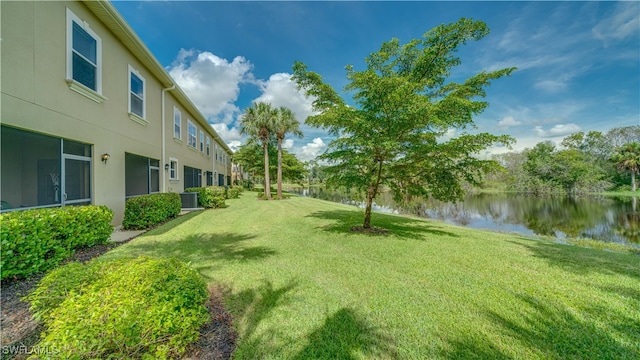 view of yard with a water view and central air condition unit