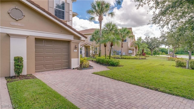 exterior space with a garage, a yard, and decorative driveway